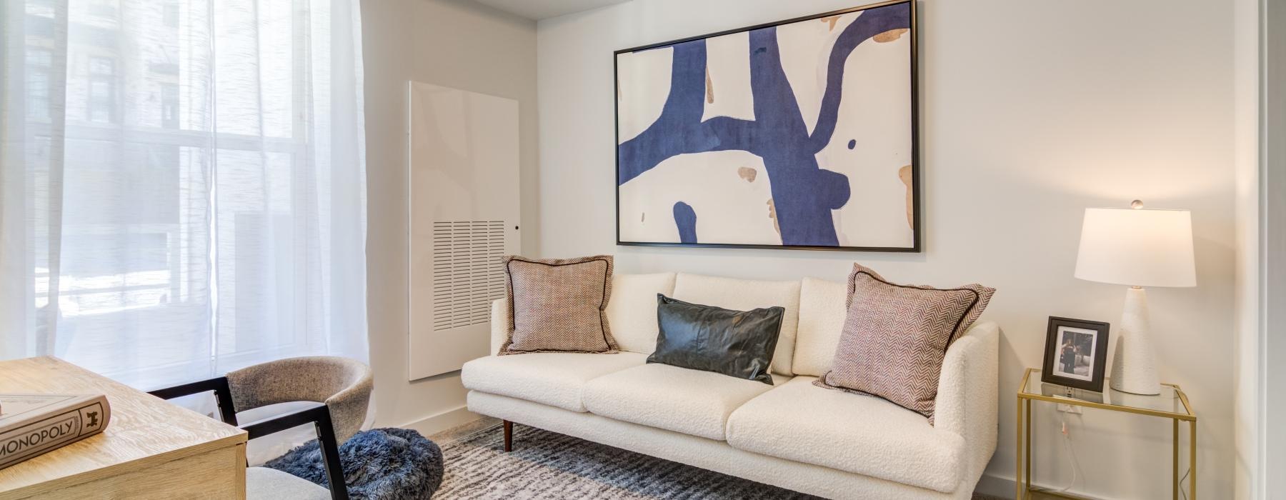 a living room with a couch and a painting on the wall