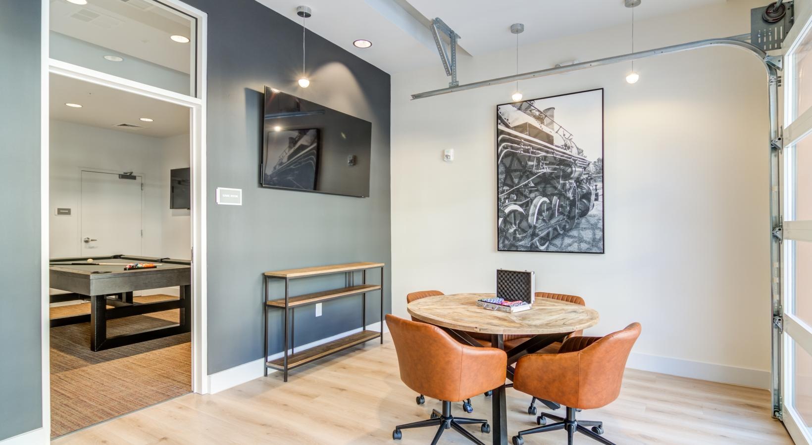 a room with a table chairs and a tv