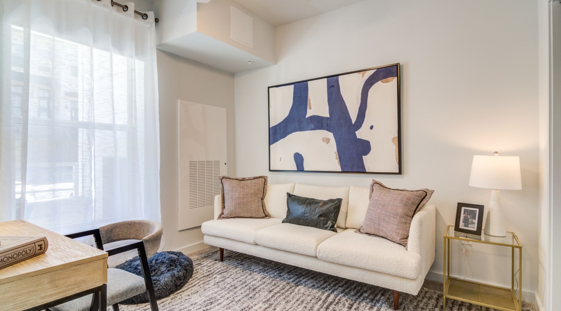 a living room with a couch and a painting on the wall